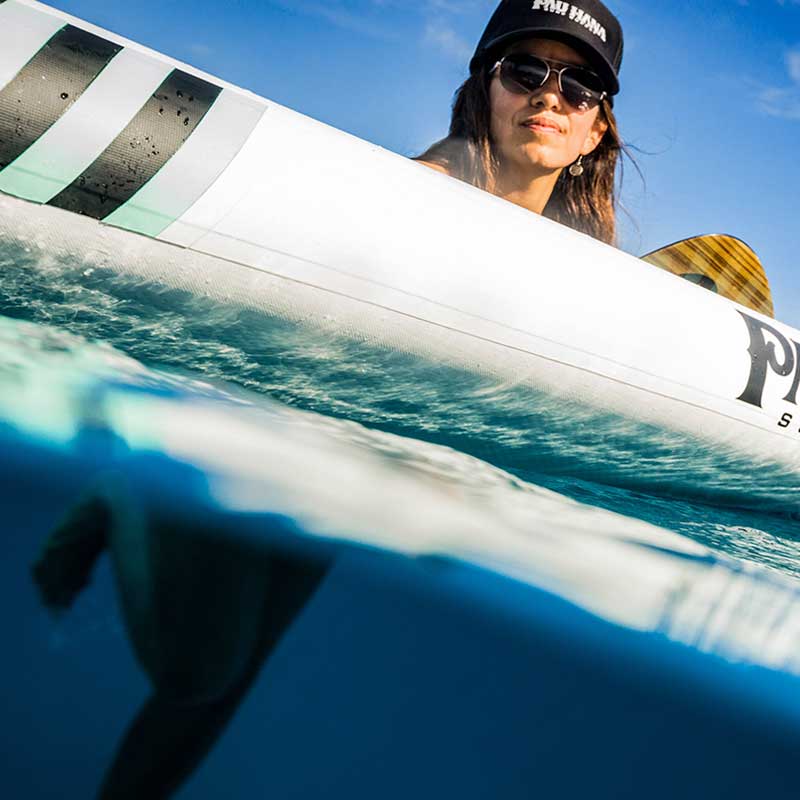 "Paddler relaxing in water on the Pau Hana Surf Supply Big EZ Air inflatable paddle board split shot"