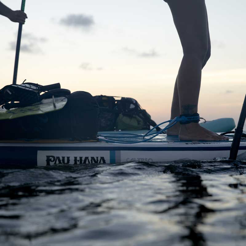 A close up image of the Pau Hana Surf Supply Calypso keel hull inflatable paddleboard loaded with kiteboarding equipment
