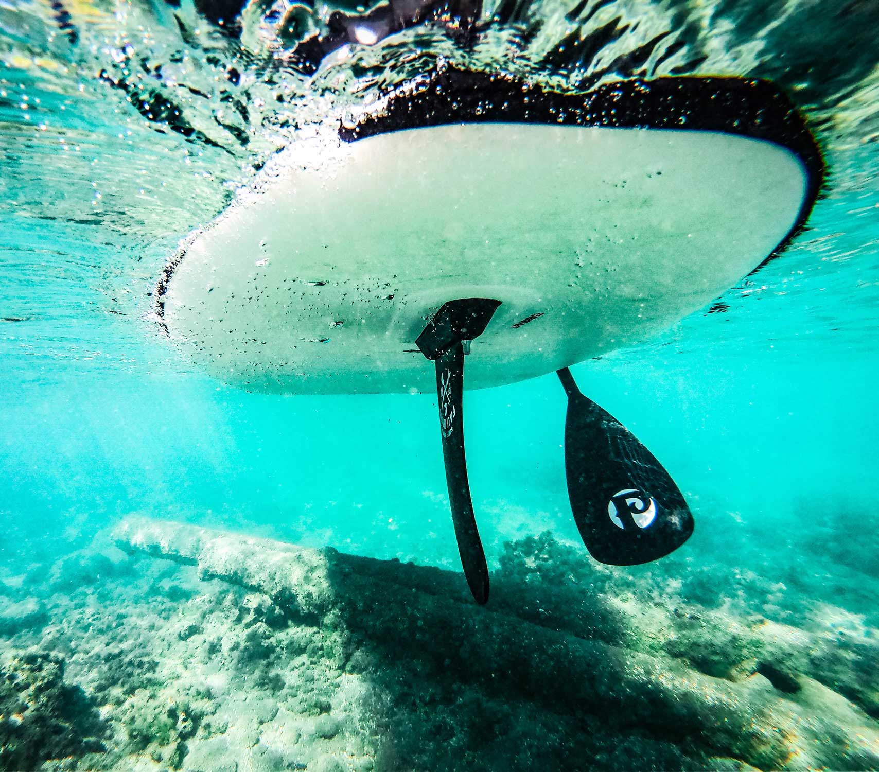 underwater image of a paddlebaord fin and paddle