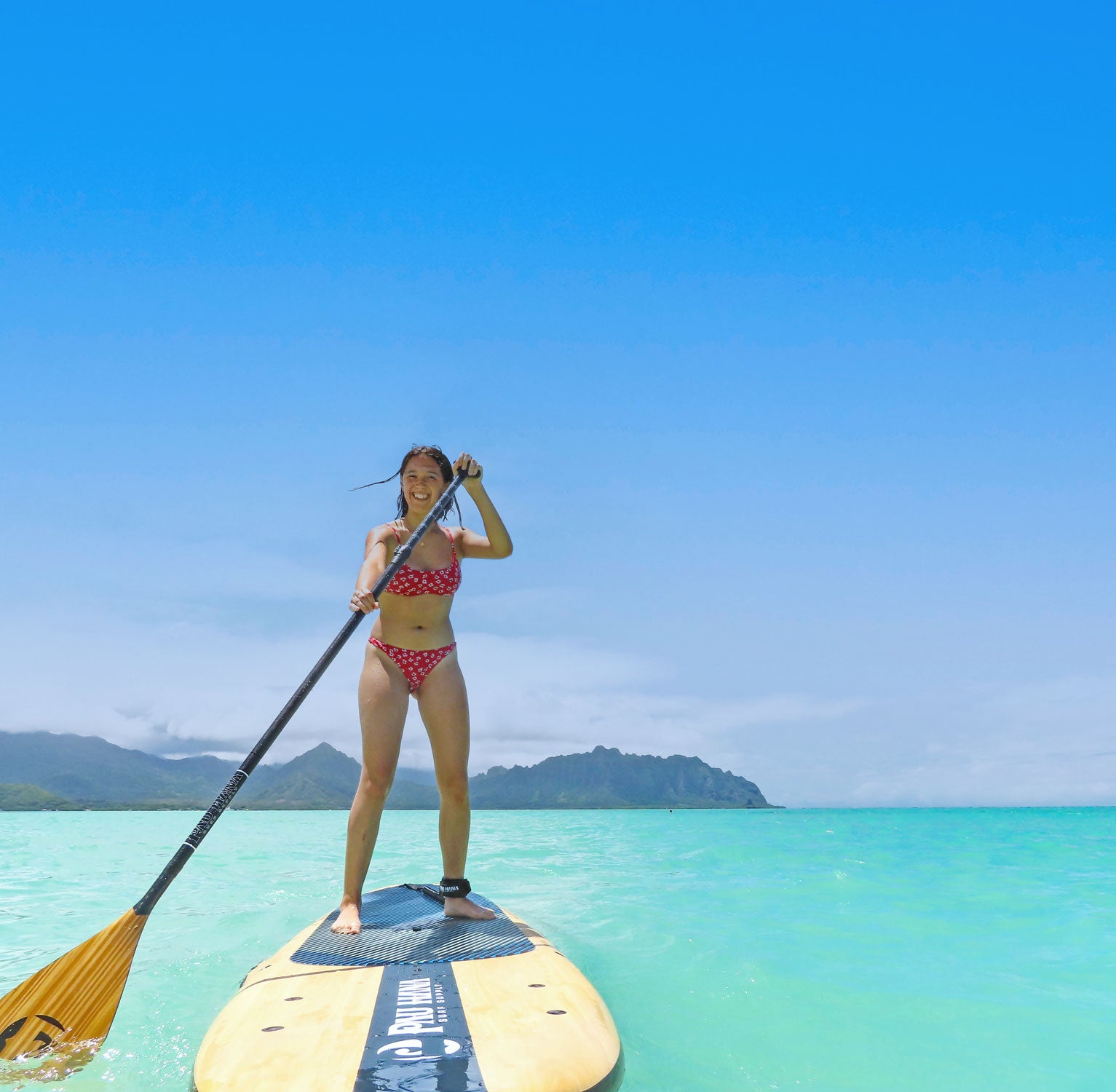 a girl paddling a paddleboard having fun in hawaii