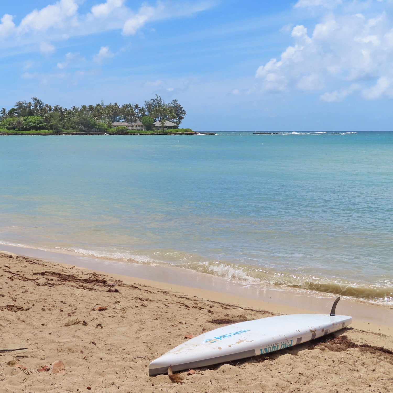 a paddleboard up side down on a beach next to the water