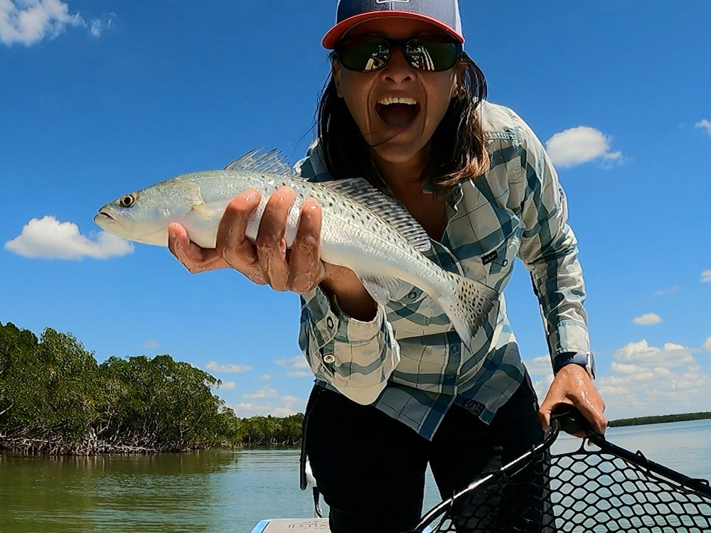 A woman holding a fish towards the camera