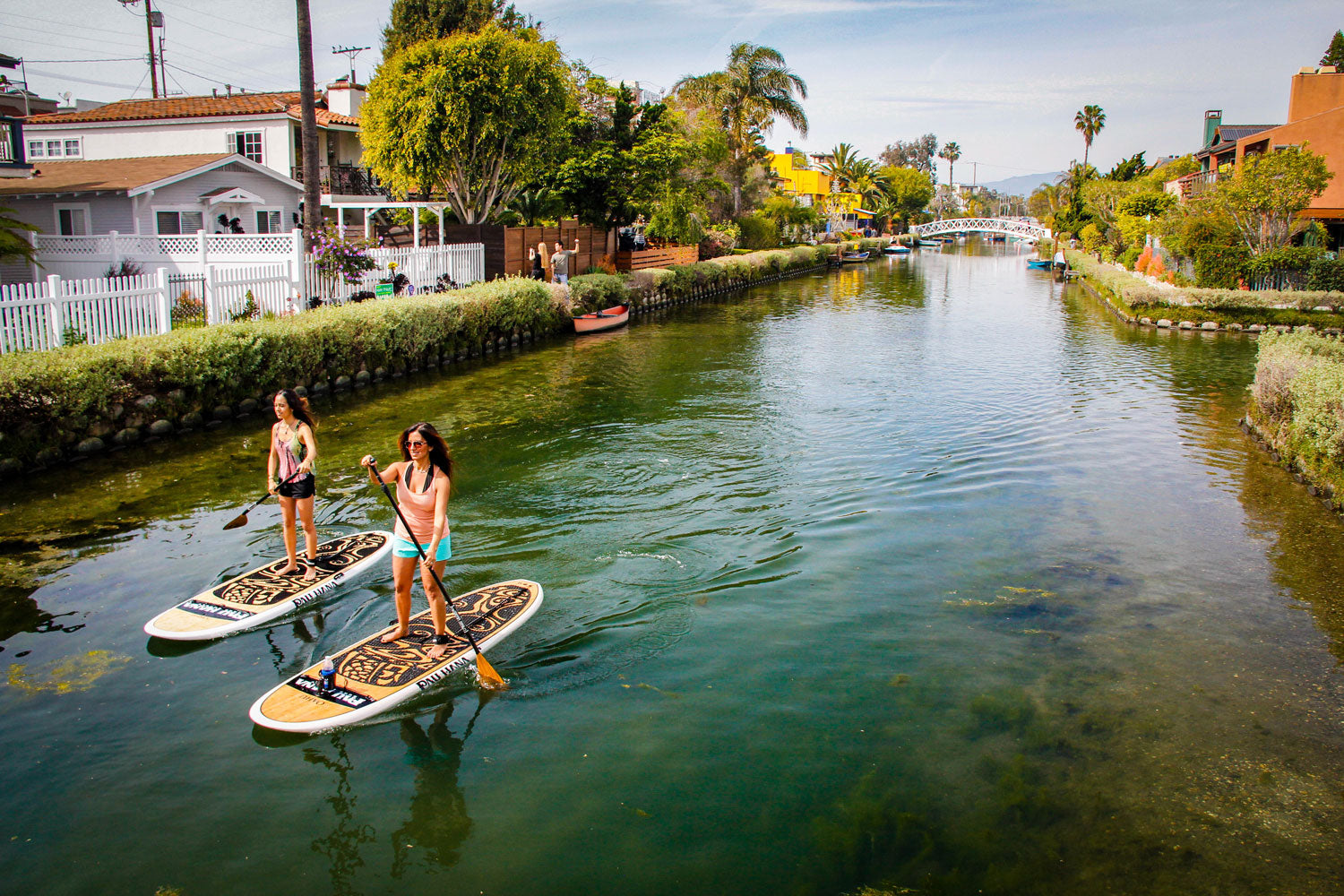 two paddleboarders on the venice canals near santa clarita in california