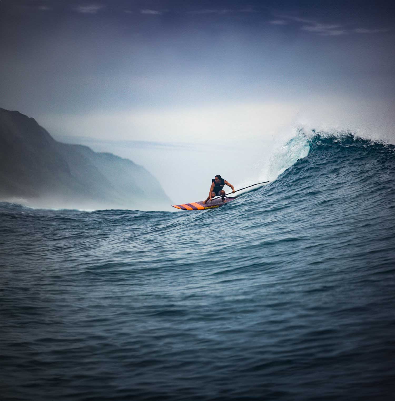 a man sup surfing aa big wave in hawaii