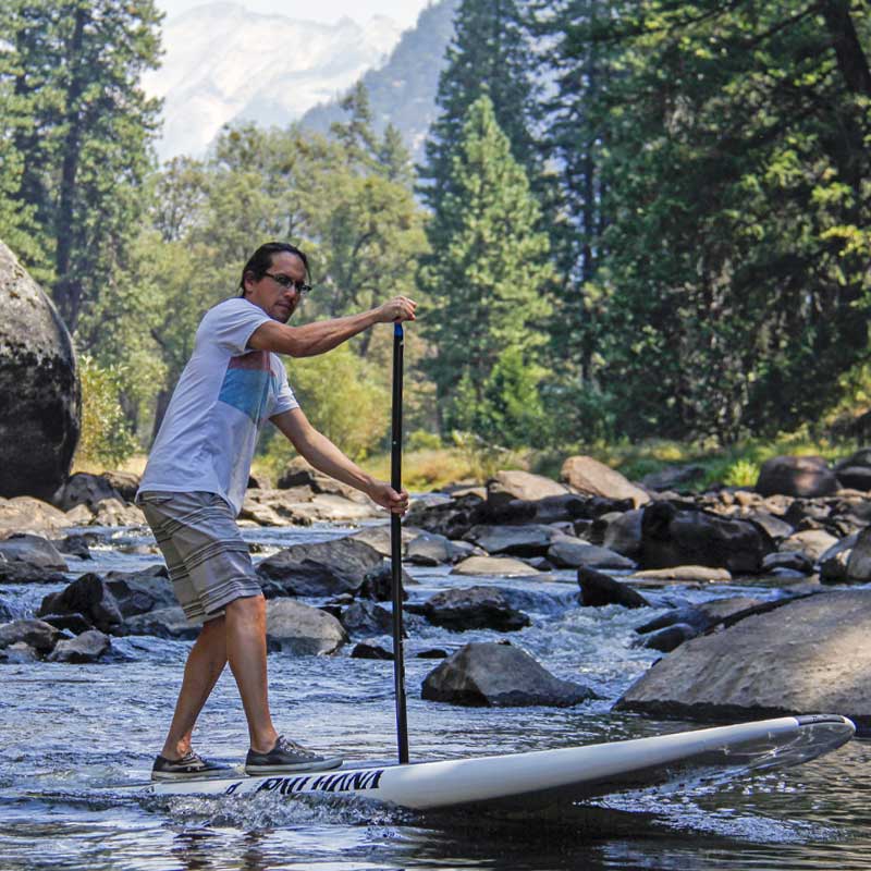 Pau Hana Surf Supply 11'0" Big EZ Hawaiian paddleboard paddler demonstrating a pivot turn on a rocky river in Yosemite National Park