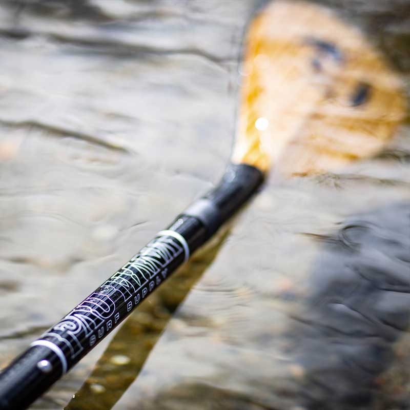 the pau hana carbon teak paddle in the water