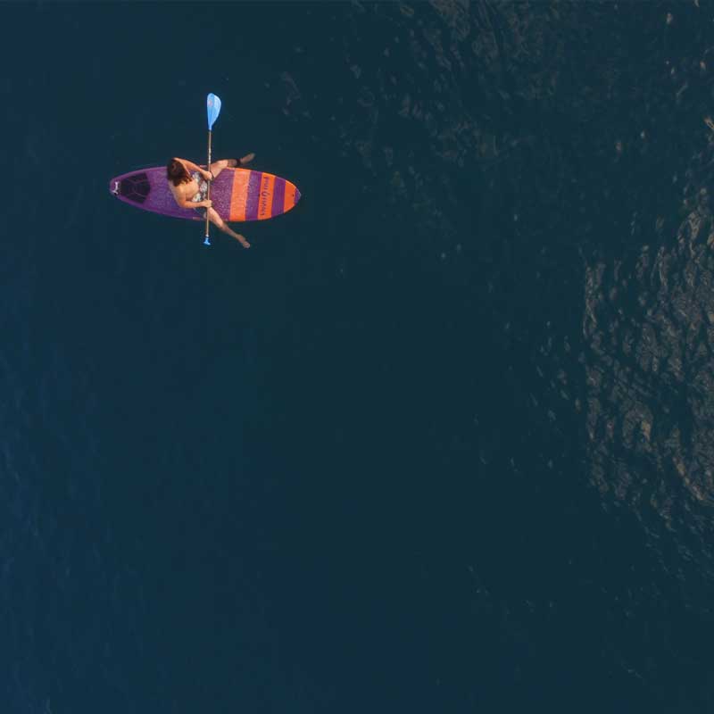 An aerial image of a surfer on the Pau Hana Surf Supply Carve surf SUP waiting for the next wave