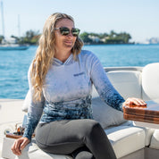 Woman sitting on a boat with water and skyline in the background