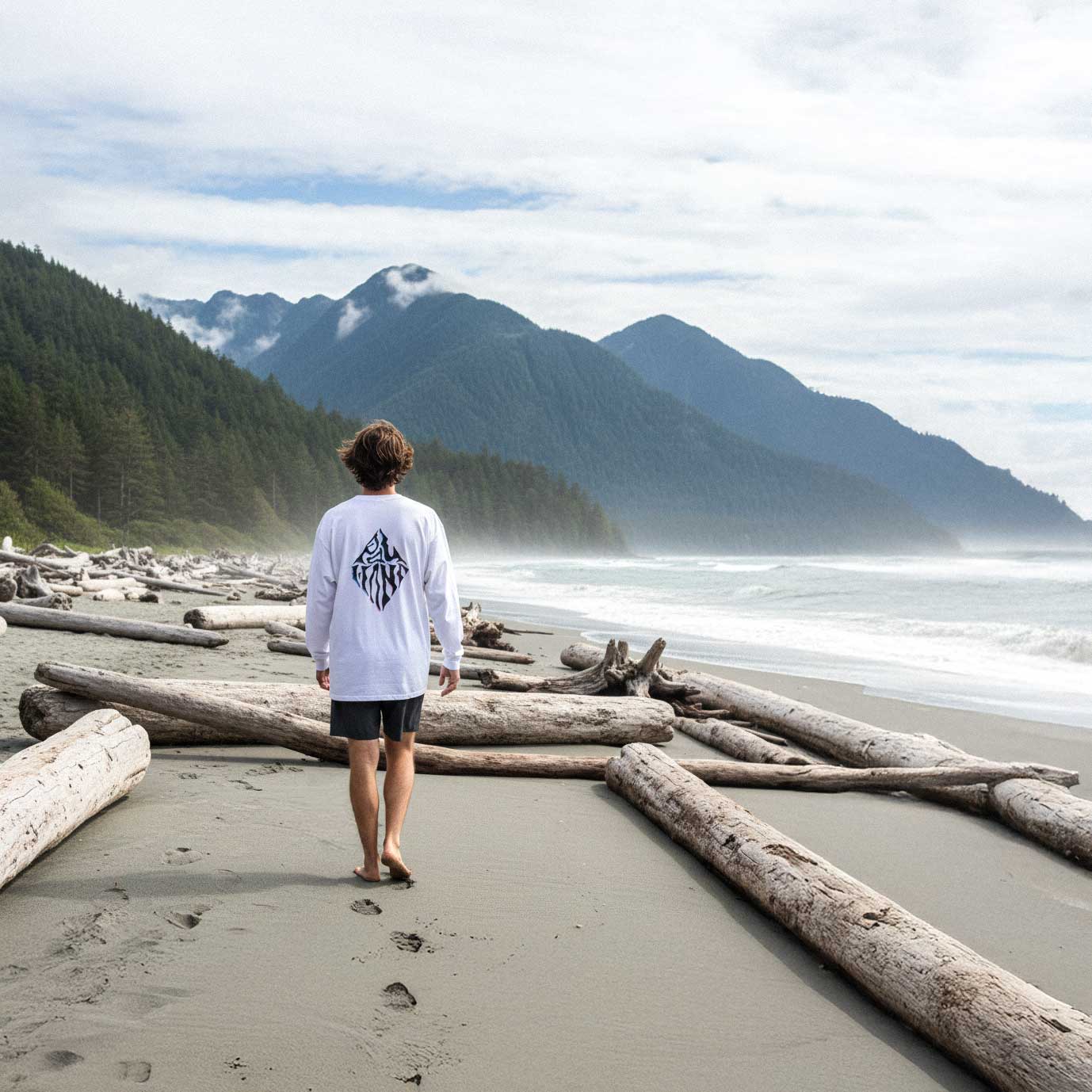 Person standing on a beach with mountains in the background