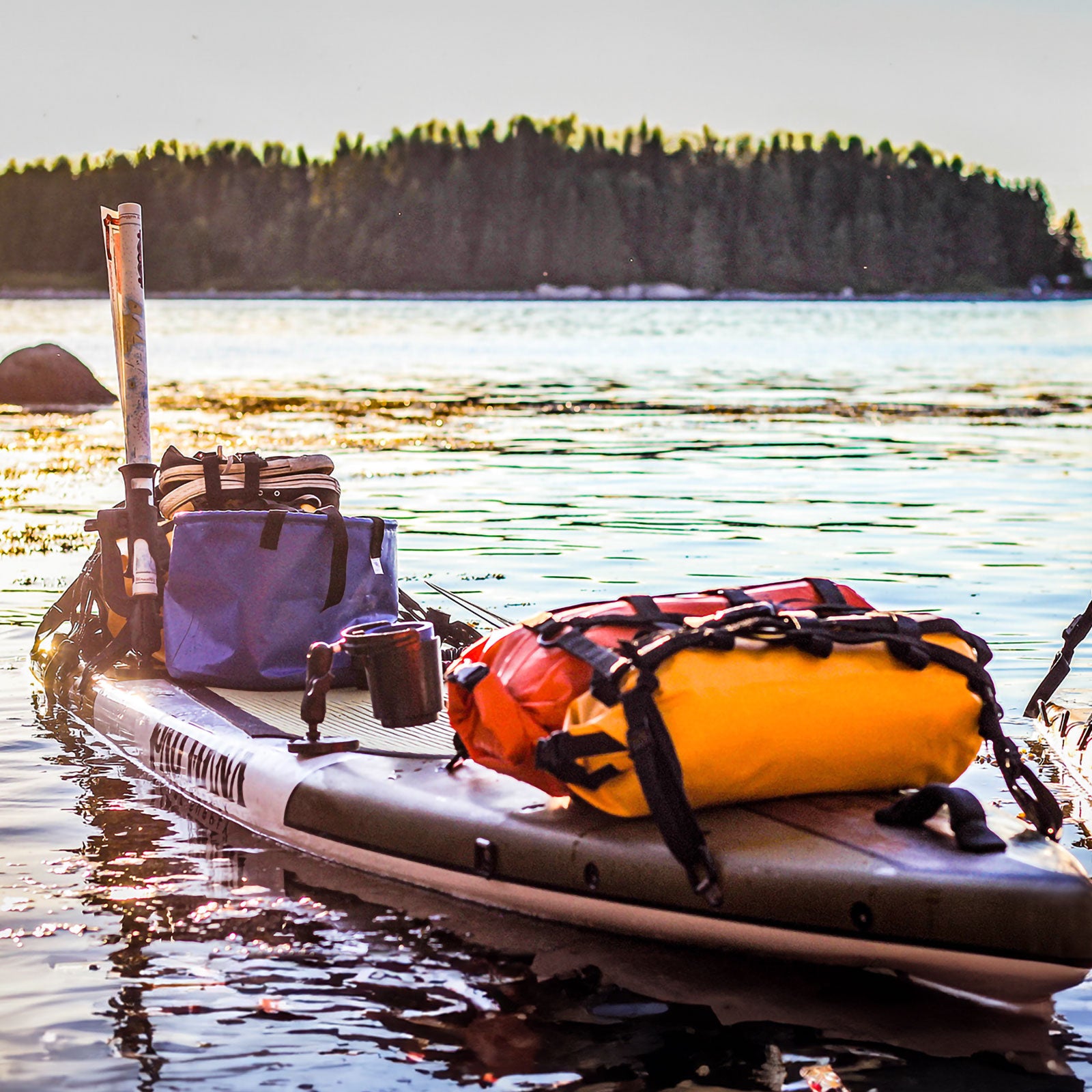 "Pau Hana Surf Supply Endurance SUP board rigged for expedition touring, loaded with waterproof gear bags on Maine coastline"