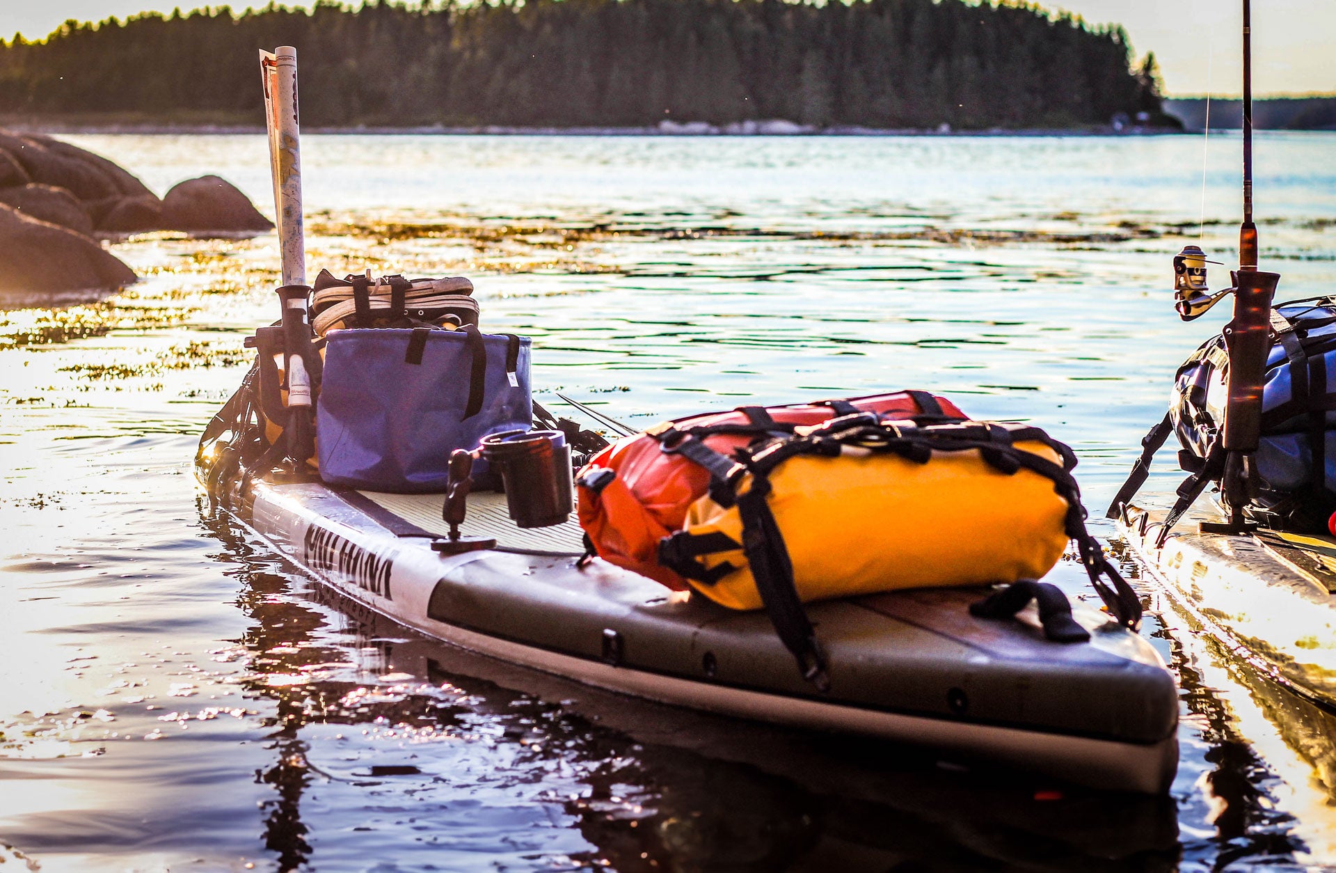 "Pau Hana Surf Supply Endurance SUP board rigged for expedition touring, loaded with waterproof gear bags on Maine coastline"