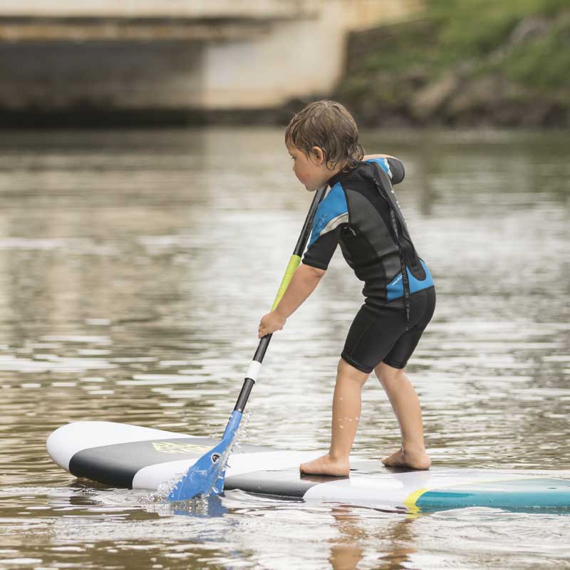 "Young paddler learning SUP technique on Pau Hana Surf Supply Grom X kids board with adjustable youth paddle"