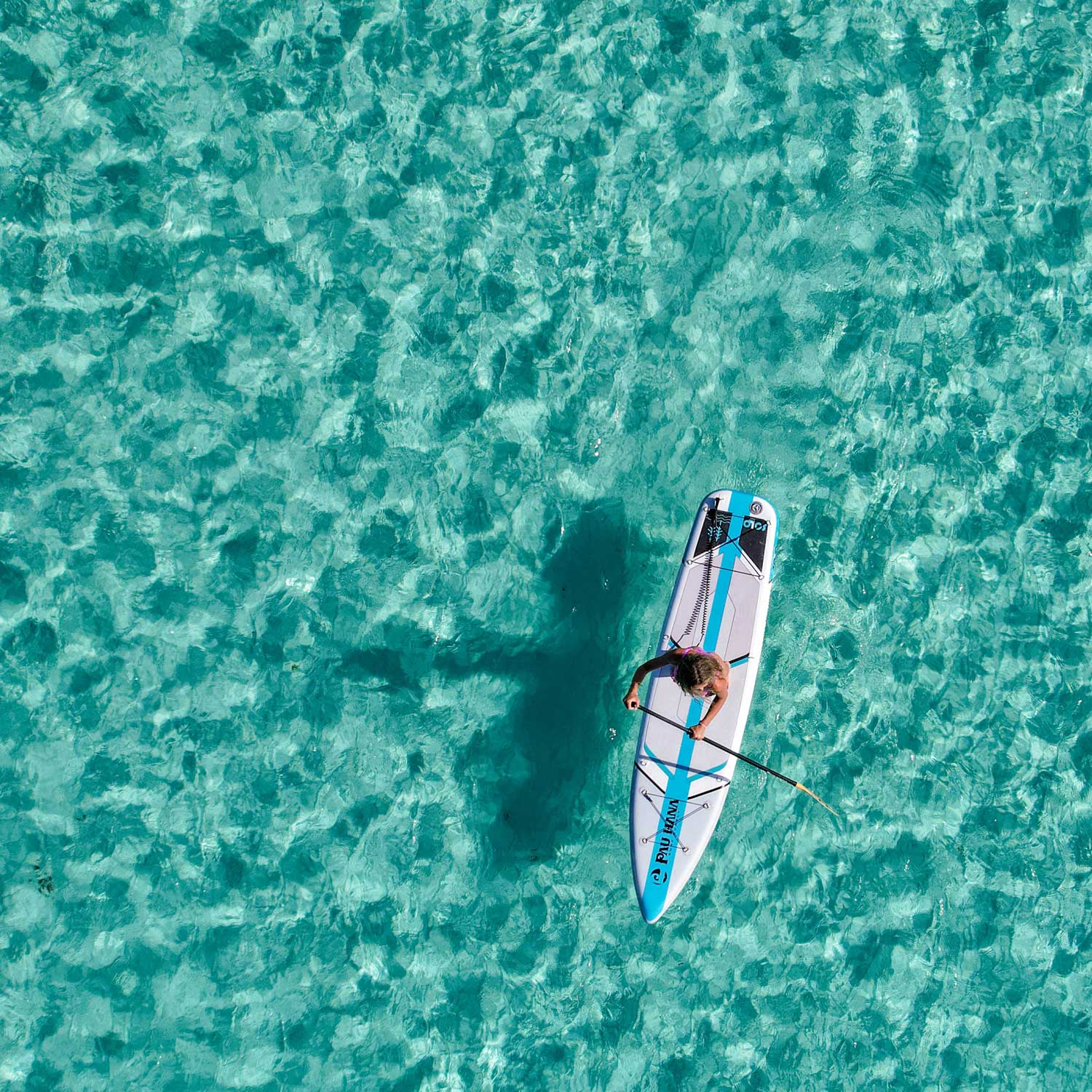 an aerial image of the solo sup backcountry inflatable paddleboard on bright blue water