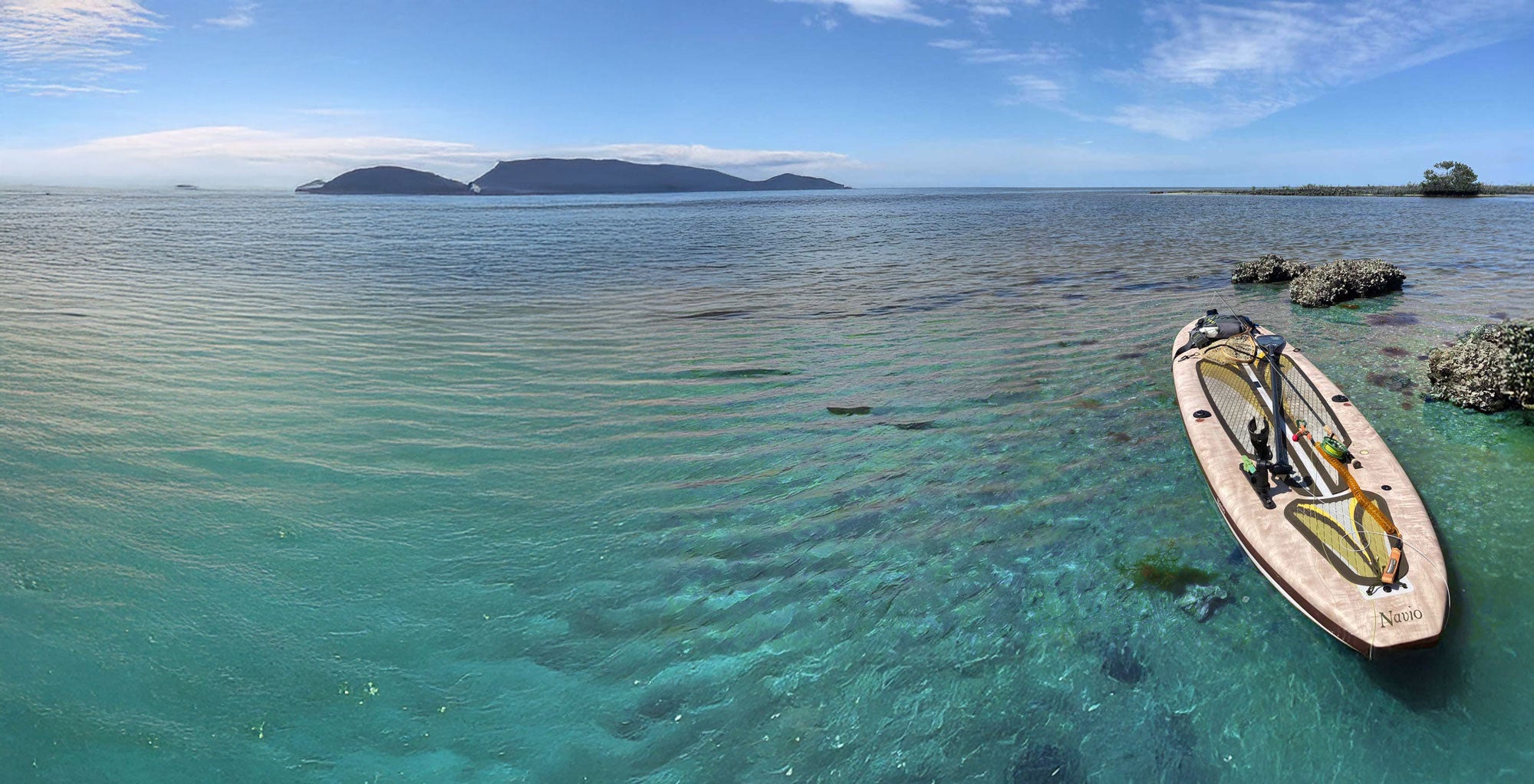 Sup floating in clear turquoise water with a scenic background of islands and blue sky.