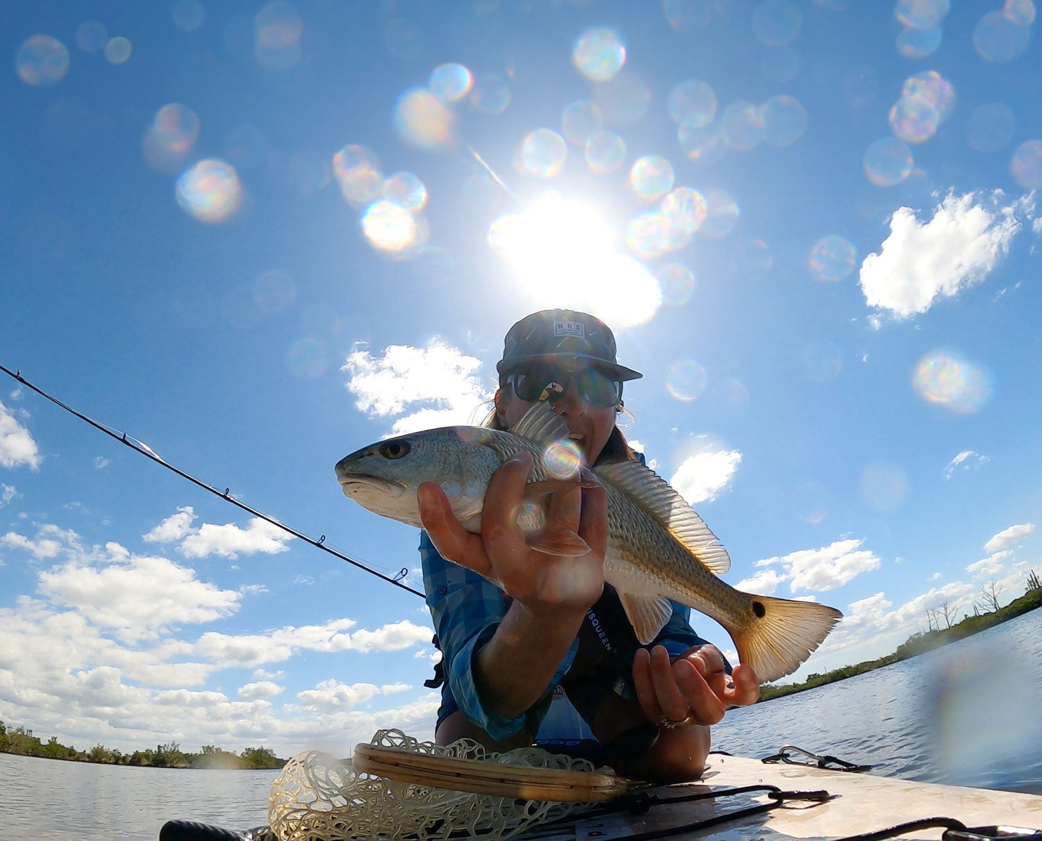 "Pau Hana Surf Supply Navio VFT board in action at Ozello, Florida, with angler displaying caught redfish during fly fishing adventure"