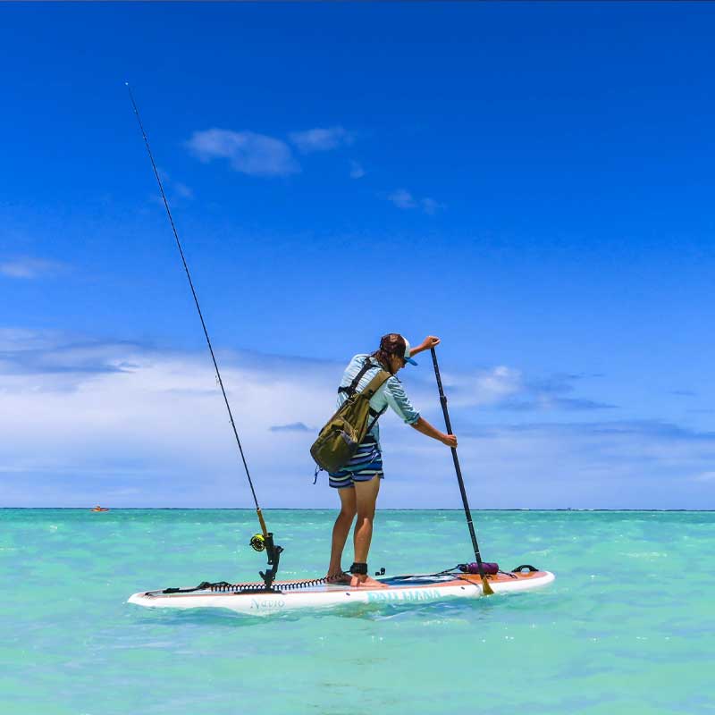 "Pau Hana Surf Supply Navio keel hull touring paddleboard fly fishing and paddling in crystal clear waters in Oahu, Hawaii"