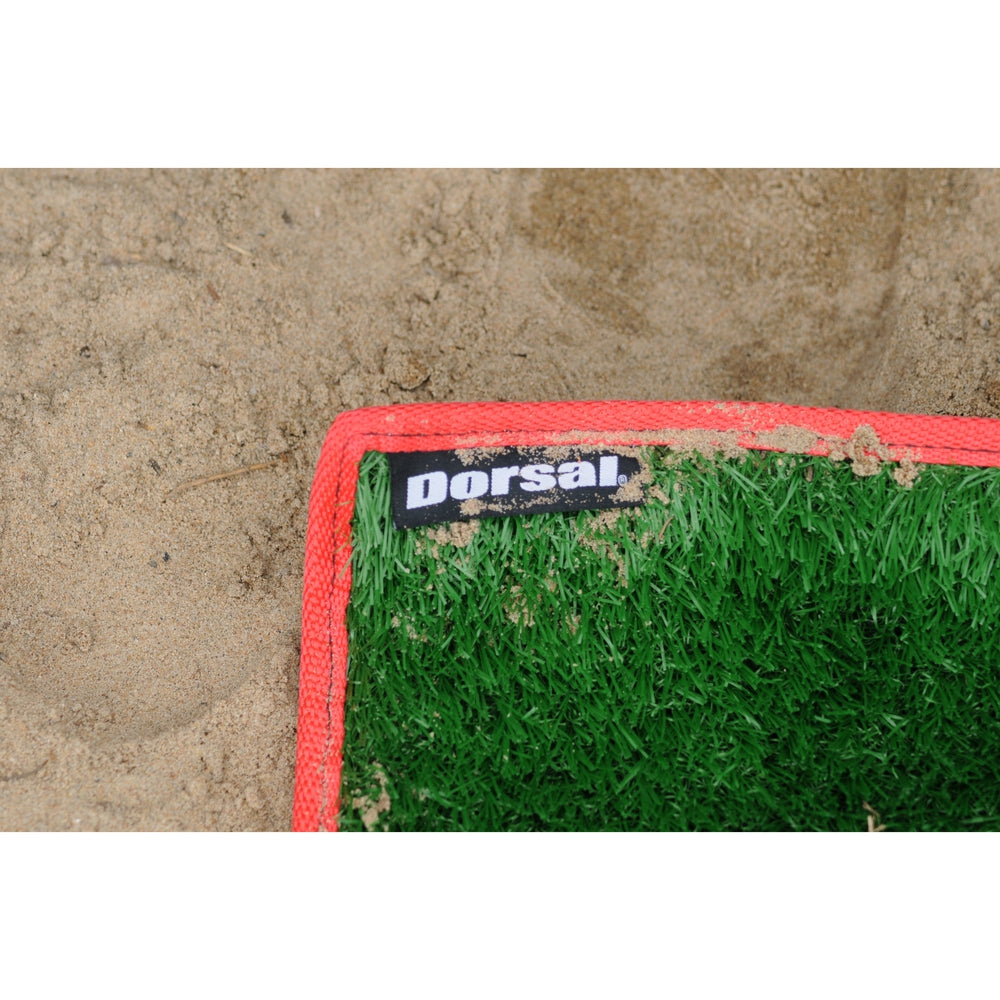 Green grass-like mat with red border and 'Dorsal' brand label on a textured surface.