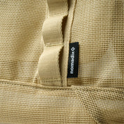 Close-up of a beige textured fabric with a 'nomadix' label.