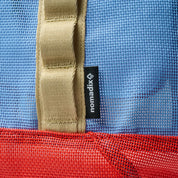 Close-up of a blue and red bag with a beige strap and a visible 'nomadix' label.