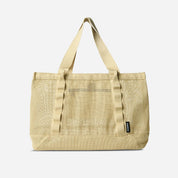 Beige tote bag with a visible brand label on a light gray background