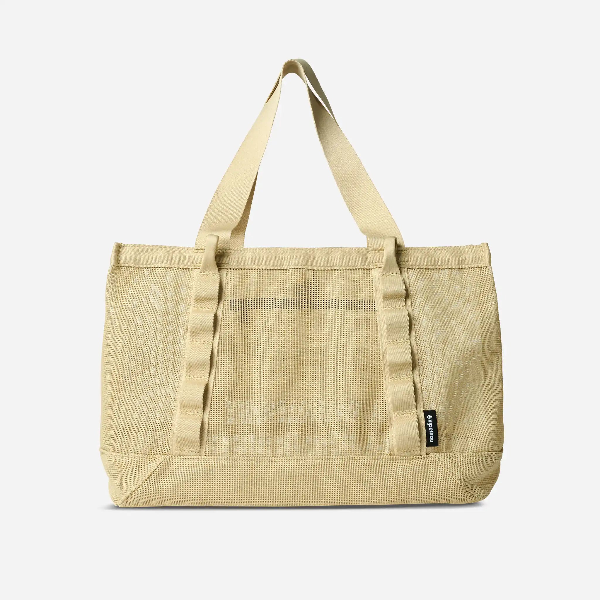 Beige tote bag with a visible brand label on a light gray background