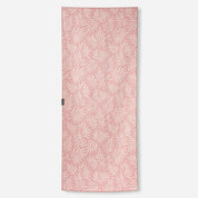 A rectangular pink towel featuring an all-over white palm leaf pattern, shown flat against a light gray background.