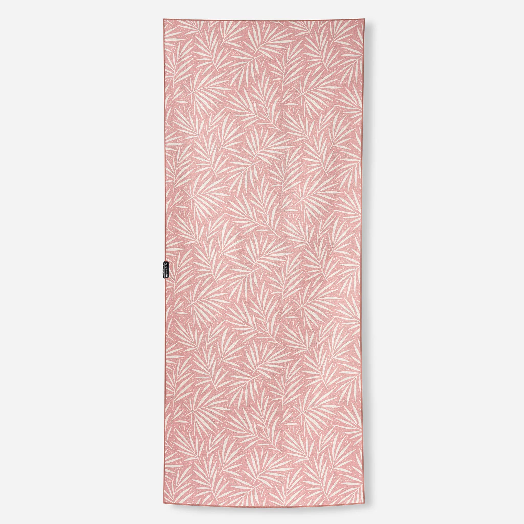 A rectangular pink towel featuring an all-over white palm leaf pattern, shown flat against a light gray background.