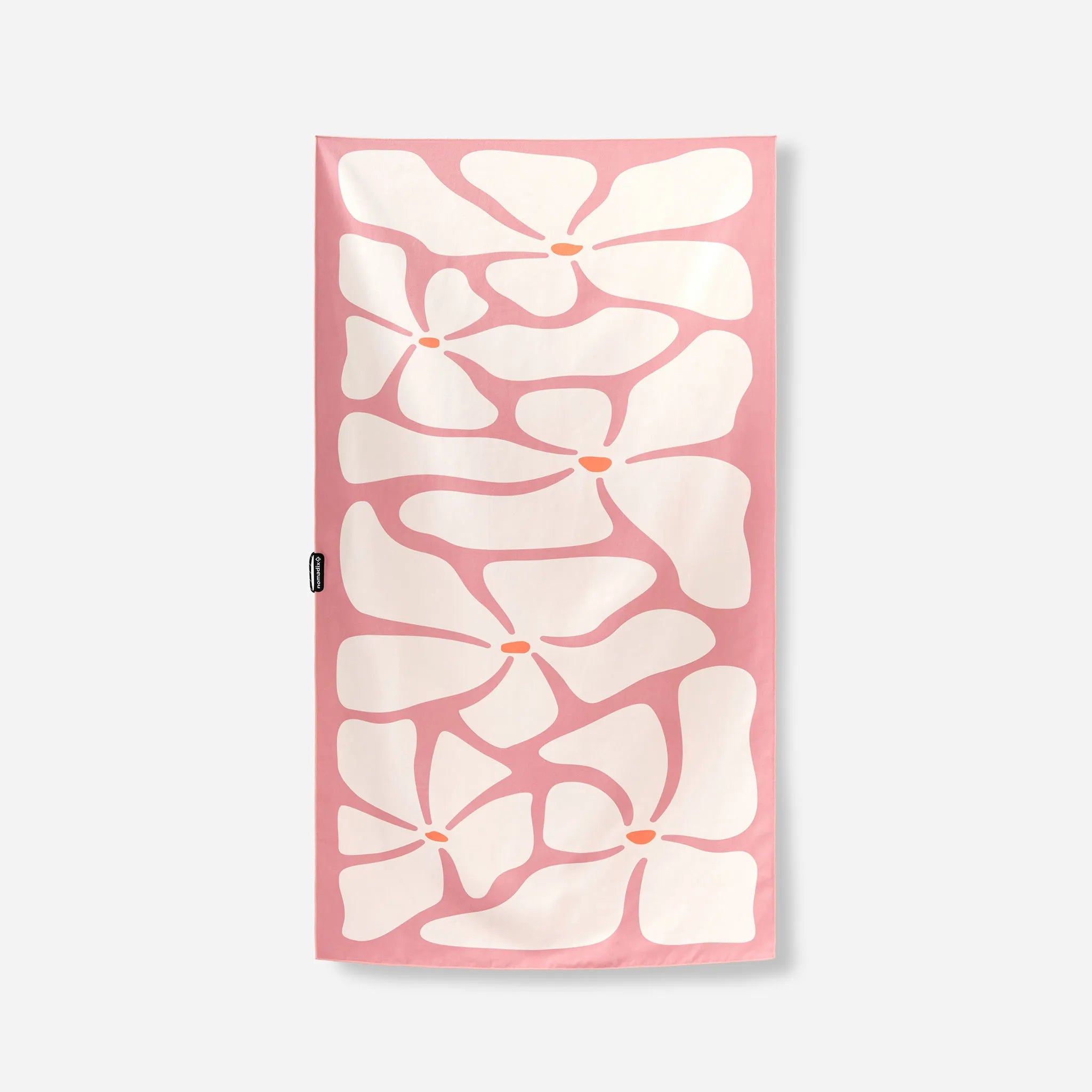 A rectangular pink towel featuring a bold white floral pattern with small orange centers, shown flat against a light gray background.