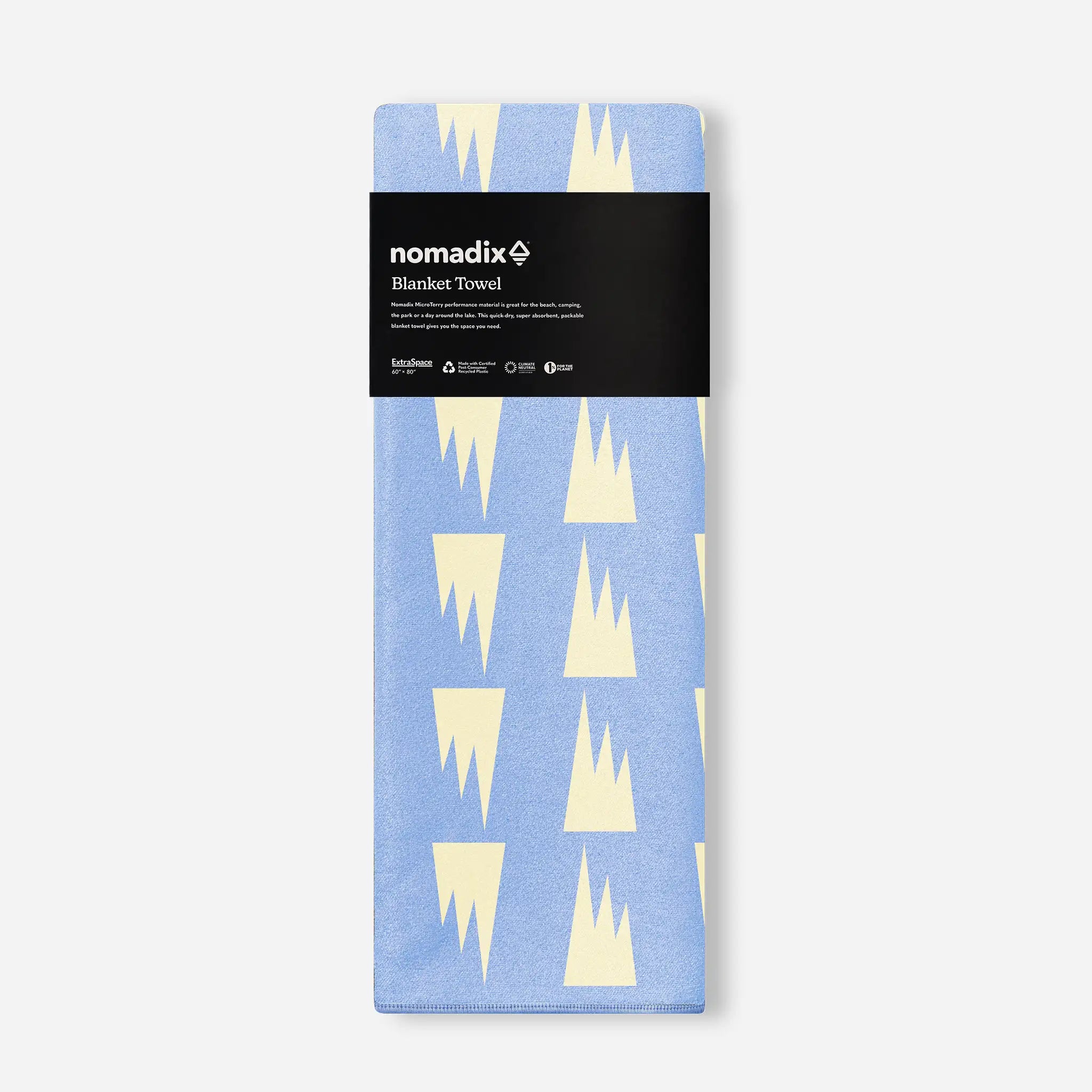 Packaged blanket towel with geometric pattern and 'nomadix' branding on a white background