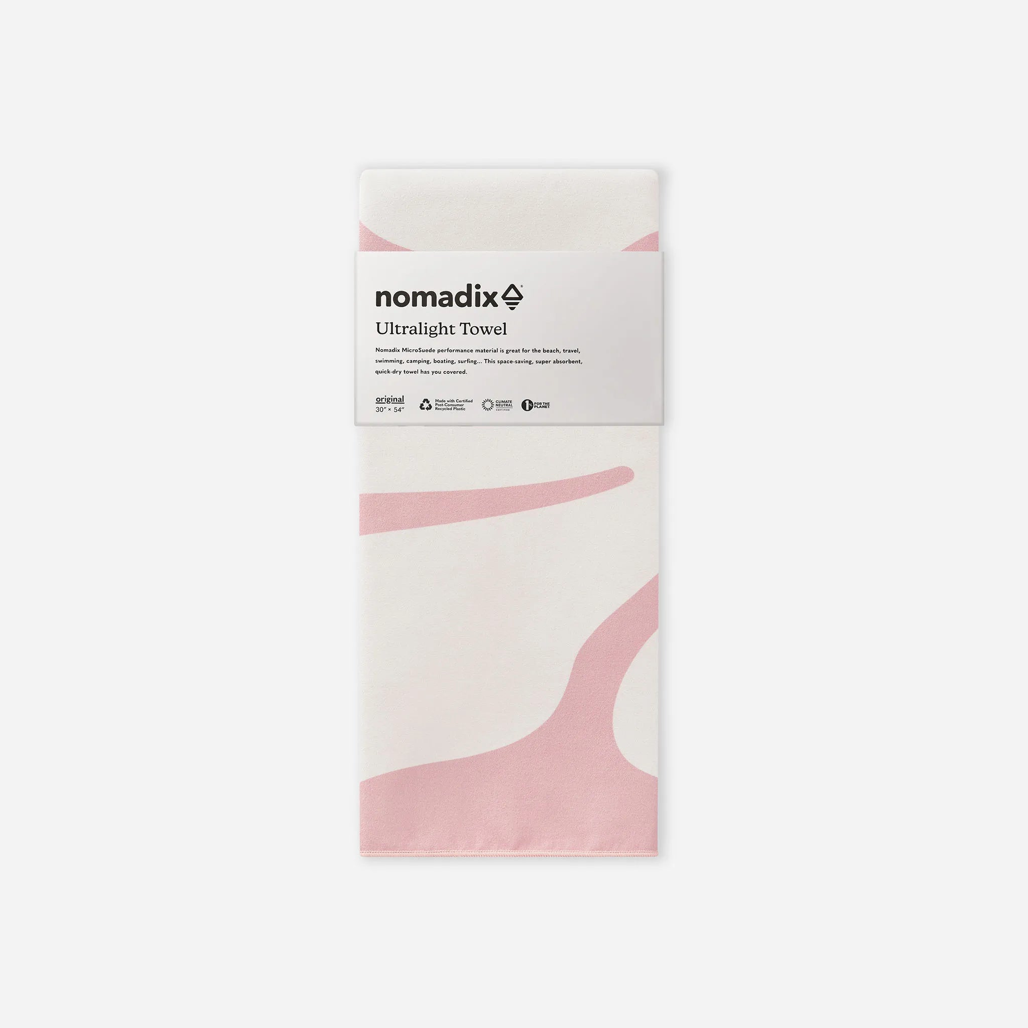 A folded white Nomadix ultralight towel with soft pink abstract wave patterns, wrapped in a white paper band labeled 'nomadix Ultralight Towel' on a light gray background.