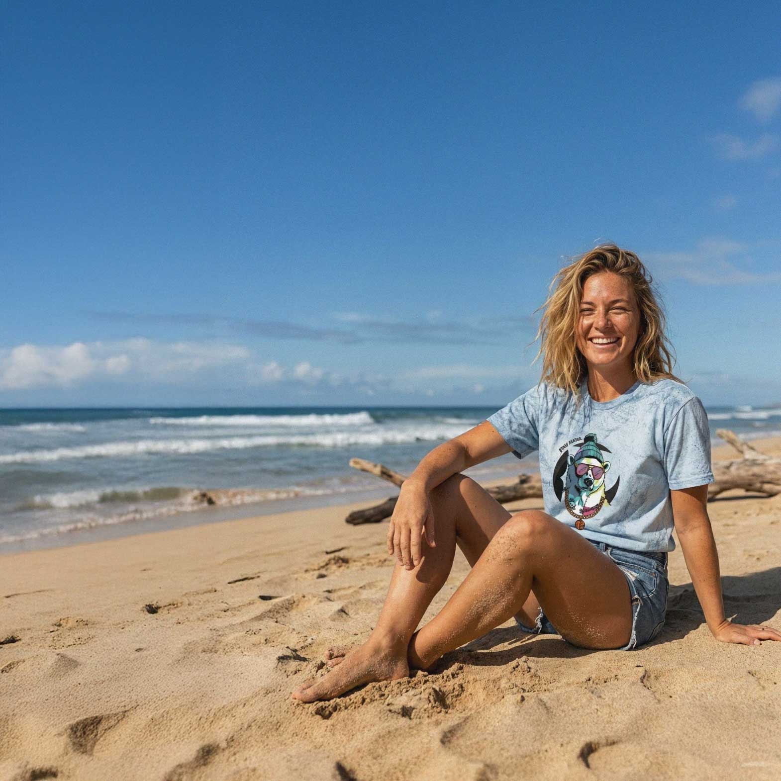 Woman sitting on a sandy beach with ocean and clear sky in the background