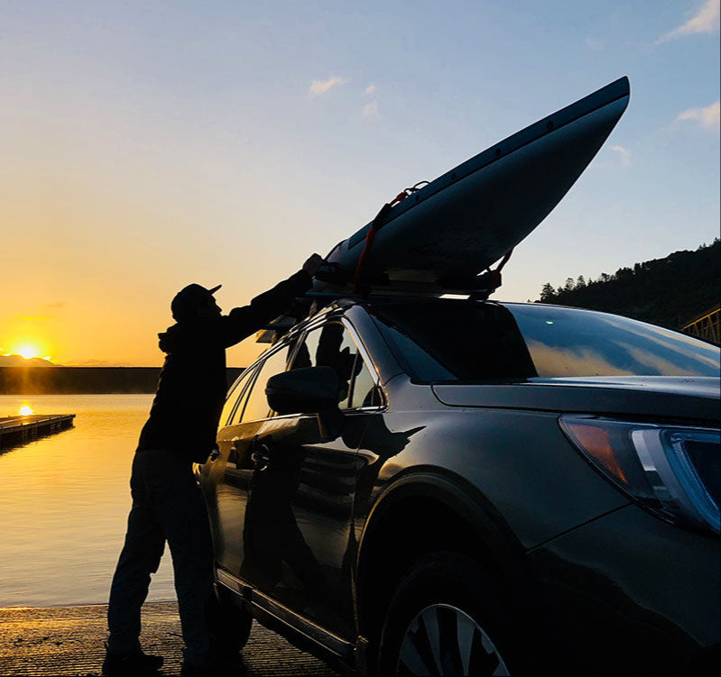 "Pau Hana Surf Supply 12'0" Endurance touring SUP loading on car roof rack  at sunset on lake boat ramp"